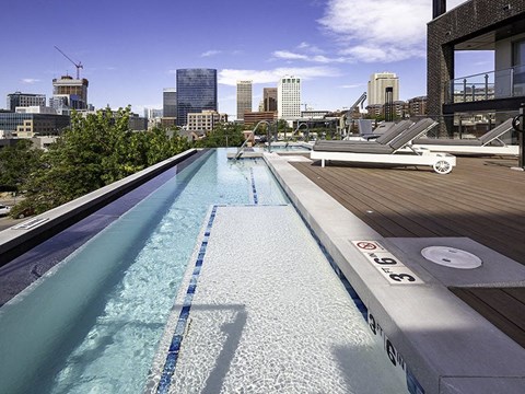 a pool on a rooftop with a city in the background